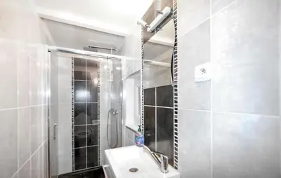 a white bathroom with a sink and a shower at Authentique Maison Piscine in Saint-Amans-Valtoret