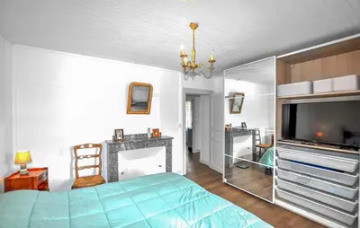 a bedroom with a bed and a flat screen tv at Authentique Maison Piscine in Saint-Amans-Valtoret