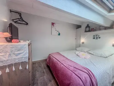 a bedroom with a bed with a pink blanket at Charmant T2 & Mezzanine Idéal pour un séjour à Gruissan in Gruissan