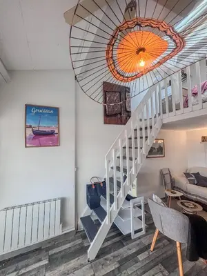 a living room with a staircase and a ceiling at Charmant T2 & Mezzanine Idéal pour un séjour à Gruissan in Gruissan