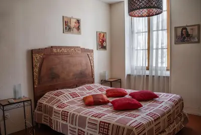 a bedroom with a bed with red pillows on it at Les Figuiers de Tamaroque in Portel-des-Corbières
