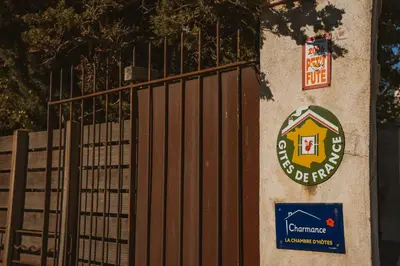 a gate with a sign on the side of a building at Les Figuiers de Tamaroque in Portel-des-Corbières