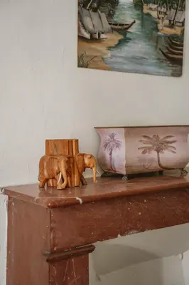 a table with two wooden statues on top of it at Les Figuiers de Tamaroque in Portel-des-Corbières