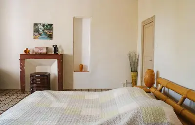 a bedroom with a bed and a fireplace at Les Figuiers de Tamaroque in Portel-des-Corbières