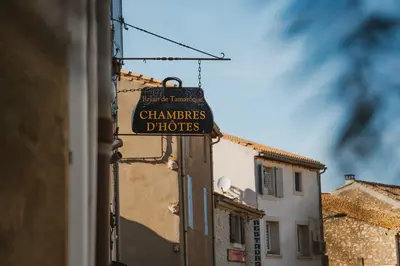 a sign for a cleaners detroit horizons hanging from a building at Le Tamaroque in Portel-des-Corbières