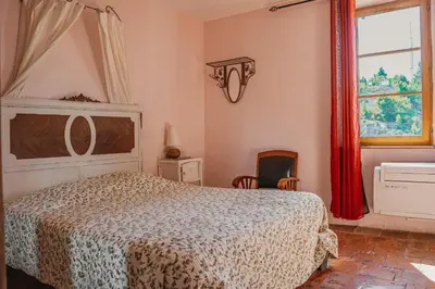 a bedroom with a bed and a window at Le Tamaroque in Portel-des-Corbières