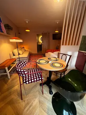 a living room with two beds and a rug at Appartement La voisine de Charles in Narbonne