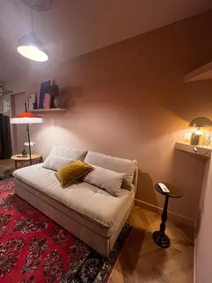 a bed with a red comforter in a bedroom at Appartement La voisine de Charles in Narbonne