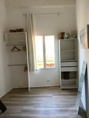 a room with white shelves and a window at La planque in Gruissan
