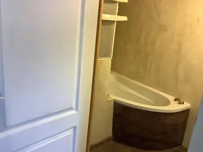 a bathroom with a bath tub next to a door at La planque in Gruissan