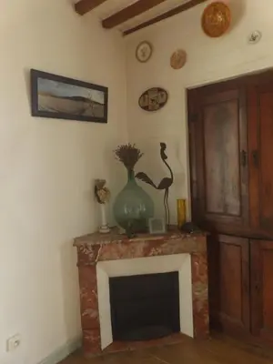 a living room with a fireplace with a vase on it at Mas cantecou in Mosset