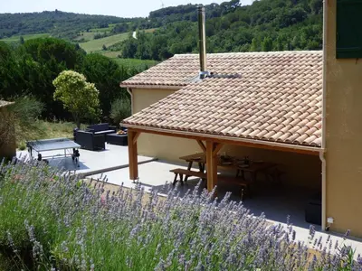 a house with a roof with a table and chairs at Villa Lana in Verzeille