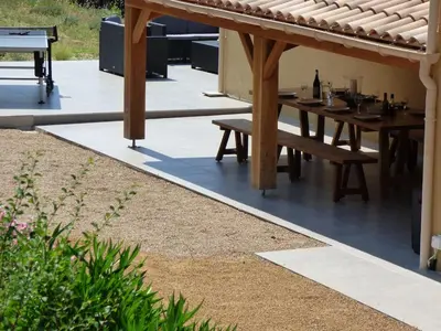 a patio with a wooden table and benches at Villa Lana in Verzeille