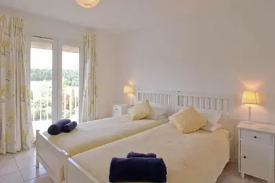 a bedroom with two beds and a large window at Villa Lana in Verzeille