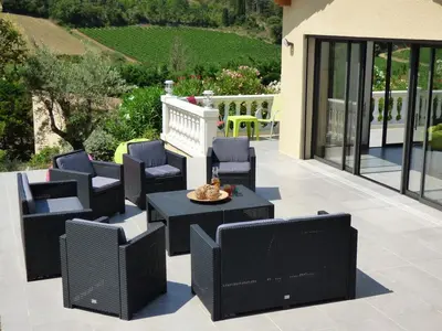 a patio with black chairs and a table at Villa Lana in Verzeille