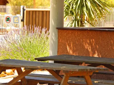 a wooden picnic table sitting next to a wall at Chalet Confort avec Terrasse - 4 Personnes - API-1-52-1742 in Villegly