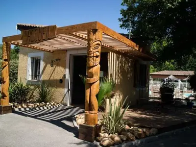 a house with a wooden pole in front of it at Chalet Confort avec Terrasse - 4 Personnes - API-1-52-1742 in Villegly