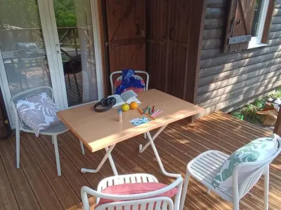 a wooden table and chairs on a porch at Chalet Confort avec Terrasse - 4 Personnes - API-1-52-1742 in Villegly