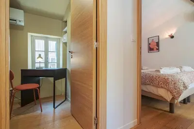 a bedroom with a bed and a desk and a mirror at La Lodge des Remparts View and Private Patio in Carcassonne