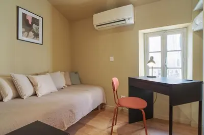 a bedroom with a bed with a desk and a desk at La Lodge des Remparts View and Private Patio in Carcassonne