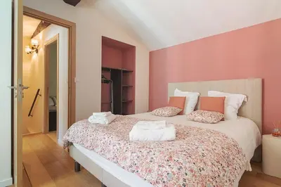 a bedroom with a large bed with pink walls at La Lodge des Remparts View and Private Patio in Carcassonne