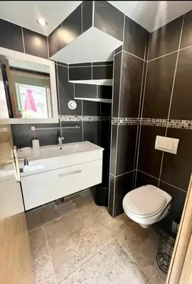 a bathroom with a white toilet and a sink at La Lodge des Remparts View and Private Patio in Carcassonne