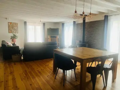 a living room with a wooden table and chairs at Las Mijeannos in Cazalrenoux