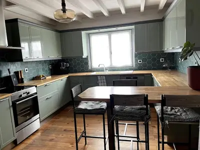 a kitchen with a wooden table and chairs in it at Las Mijeannos in Cazalrenoux