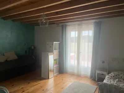a living room with a bed and a window and a table at Las Mijeannos in Cazalrenoux