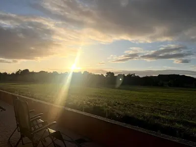 a chair sitting on a porch next to a field at Las Mijeannos in Cazalrenoux