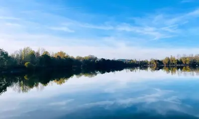 a view of a lake with trees in the background at Maison de village, Route des lacs in Le Bez