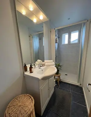a bathroom with a sink and a large mirror at Maison de village, Route des lacs in Le Bez