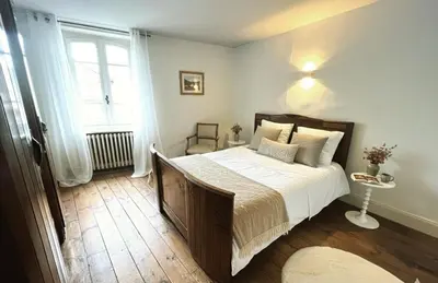 a bedroom with a large bed and a window at Maison de village, Route des lacs in Le Bez