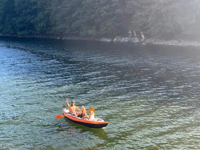 a group of people in a boat on a lake at Maison de village, Route des lacs in Le Bez