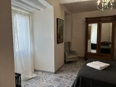 a bedroom with a bed and a window and a mirror at Spacious house in the center of Quillan in Quillan