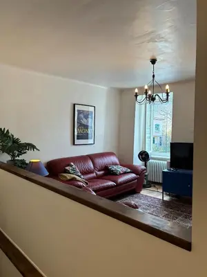 a living room with a red leather couch at Spacious house in the center of Quillan in Quillan