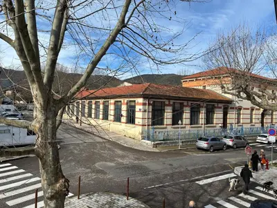 a building with cars parked in front of a street at Spacious house in the center of Quillan in Quillan
