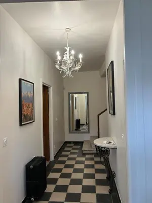 a hallway with a checkered floor and a chandelier at Spacious house in the center of Quillan in Quillan