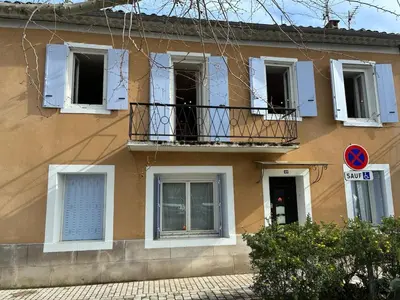 a building with white windows and a balcony at Spacious house in the center of Quillan in Quillan