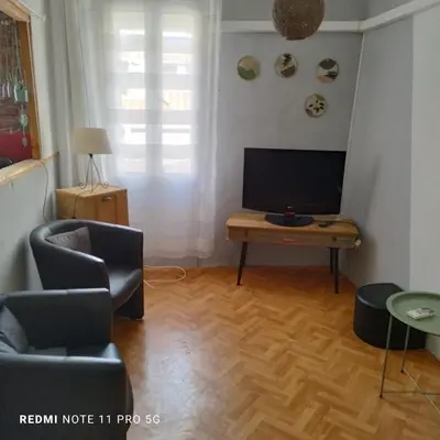 a living room with a television and a table at Charmant T2 de 43 m2 in Port-la-Nouvelle