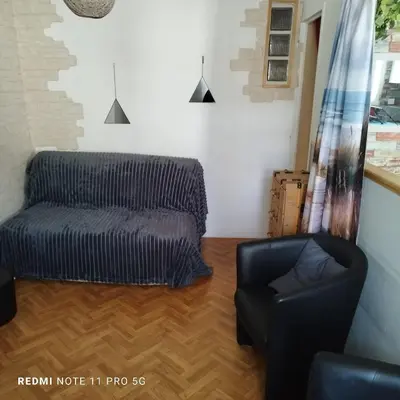 a living room with a couch and a chair at Charmant T2 de 43 m2 in Port-la-Nouvelle