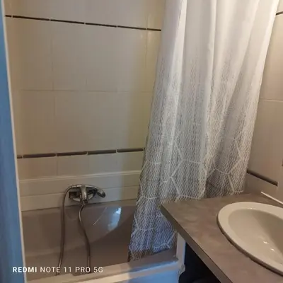 a bathroom with a shower curtain and a sink at Charmant T2 de 43 m2 in Port-la-Nouvelle