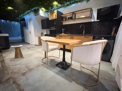 a kitchen with a wooden table and two chairs at Love Room végétale n102 in Narbonne