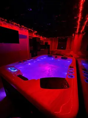 a hot tub in a room with red lights at Love Room végétale n102 in Narbonne