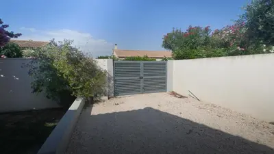 a white fence with a gate in a yard at Villa Élégance in Peyriac-de-Mer