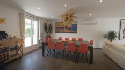 a dining room with a table and orange chairs at Villa Élégance in Peyriac-de-Mer