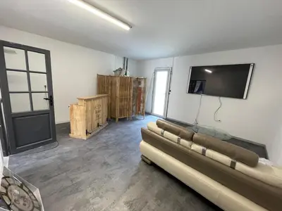 a living room with a couch and a flat screen tv at Villa Élégance in Peyriac-de-Mer