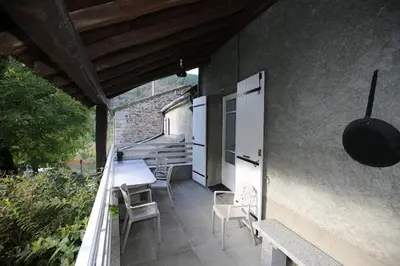 a patio with chairs and a table on a balcony at Maison de vacances, gîte au calme en pleine nature, le Frêne in Lacrouzette