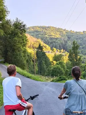 two people riding bikes down a road at Maison de vacances, gîte au calme en pleine nature, le Frêne in Lacrouzette