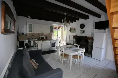 a living room and kitchen with a couch and a table at Maison de vacances, gîte au calme en pleine nature, le Frêne in Lacrouzette